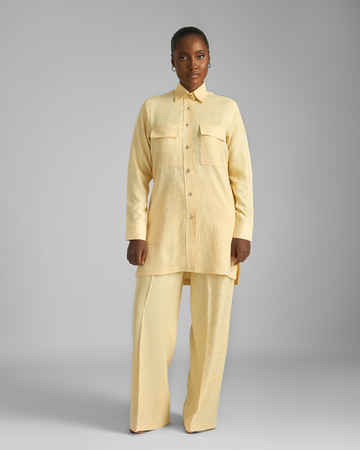 Person wearing a beige suit on a gray background