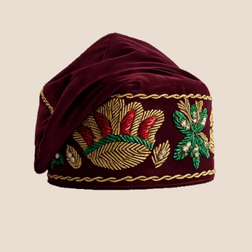 Maroon embroidered turban with gold, red, and green patterns on a white background